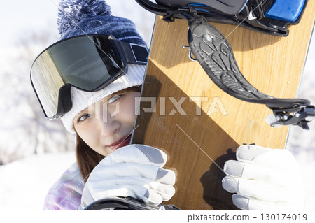 Cute woman enjoying snowboarding 130174019