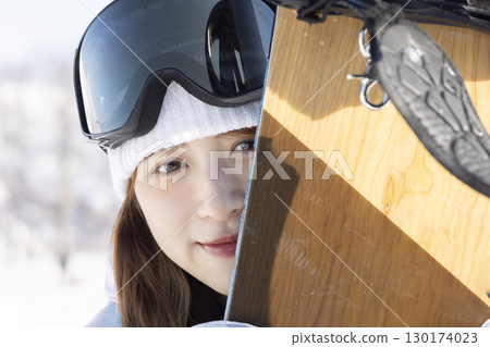 Cute woman enjoying snowboarding 130174023