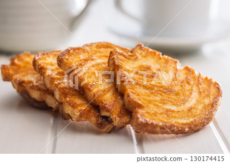 Le sfoglie. Crispy sweet pastry on white table. Le sfoglie. Crispy sweet pastry on white table. 130174415