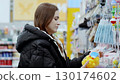 Woman happily choosing rubber ducks at the supermarket for her children, enjoying a relaxed weekend outing 130174602