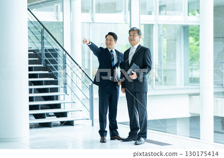 Business people walking down an office corridor 130175414