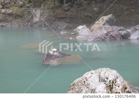 Strangely shaped rocks floating in the emerald green sea Strangely shaped rocks floating in the emerald green sea 130176406