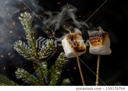 Two marshmallows are grilling over an open flame, surrounded by sparks and smoke, with a pine tree in the background during a cozy evening Two marshmallows are grilling over an open flame, surrounded by sparks and smoke, with a pine tree in the background during a cozy evening 130176764