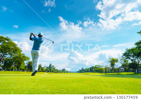 藍天下高爾夫球手擊球的後視圖 藍天下高爾夫球手擊球的後視圖 130177459