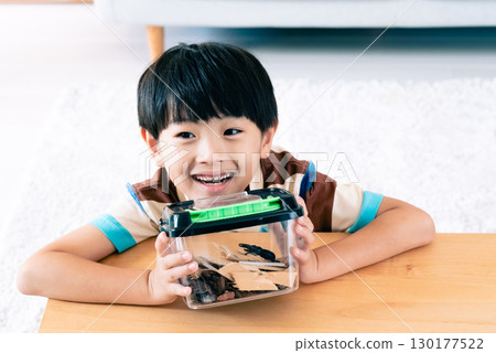 一個男孩正在觀察一隻鍬形蟲 130177522