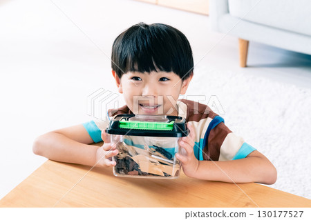 一個男孩正在觀察一隻鍬形蟲 130177527