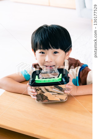 一個男孩正在觀察一隻鍬形蟲 130177529