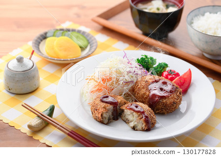 Steaming freshly fried croquette set meal with shredded cabbage, rice, miso soup and pickles for a Japanese lunch 130177828