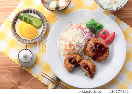 Steaming freshly fried croquette set meal with shredded cabbage, rice, miso soup and pickles for a Japanese lunch Steaming freshly fried croquette set meal with shredded cabbage, rice, miso soup and pickles for a Japanese lunch 130177831