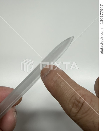 A man taking care of his fingernails with nail file 130177947
