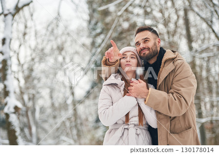 Showing and discovering new places. Lovely couple have a walk in the winter forest 130178014