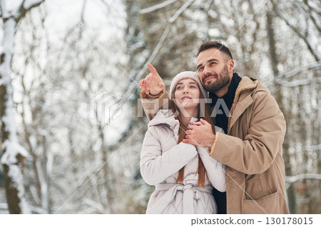 Showing and discovering new places. Lovely couple have a walk in the winter forest 130178015