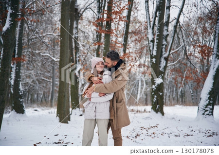Cheerful facial expression. Lovely couple have a walk in the winter forest 130178078