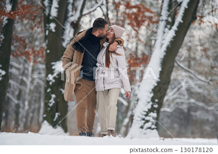 Lovely couple have a walk in the winter forest Lovely couple have a walk in the winter forest 130178120