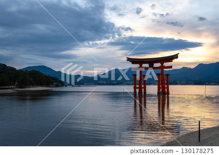 Famous red torii gate of Itsukushima shrine at sunset in Miyajima, Japan 130178275