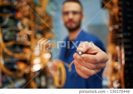 Close up view of man hand that is holding internet cable 130178446