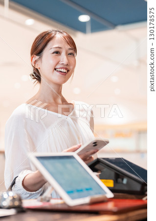 Cashless smartphone payment young woman 130178575