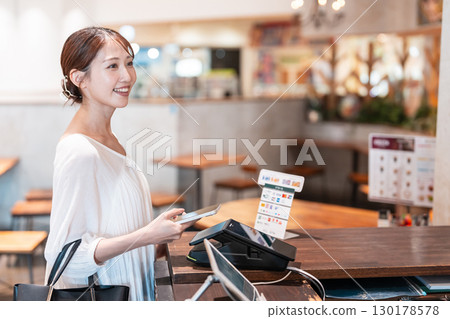 Cashless smartphone payment young woman 130178578