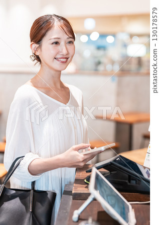 Cashless smartphone payment young woman Cashless smartphone payment young woman 130178579