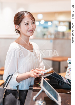 Cashless smartphone payment young woman 130178583