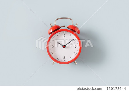 Red alarm clock on blue background. 130178644