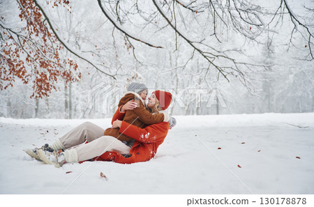 Embracing each other. Mother and her daughter is on the winter meadow and forest 130178878