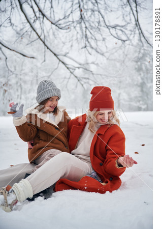 On the snow. Mother and her daughter is on the winter meadow and forest 130178891