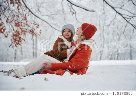 On the snow. Mother and her daughter is on the winter meadow and forest 130178893