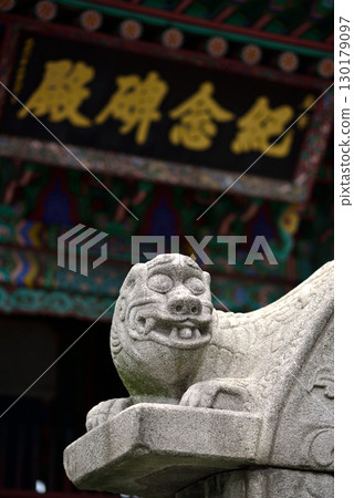 Stone lion statue in front of a traditional Asian temple with ornate roof in Seoul, South Korea Stone lion statue in front of a traditional Asian temple with ornate roof in Seoul, South Korea 130179097