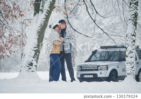 Beautiful nature. Couple is standing near the car in the winter forest 130179324