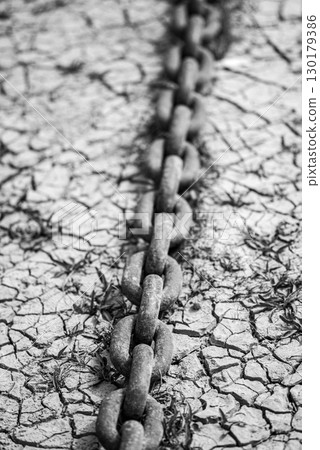 Rusty Chain on Cracked Ground in Black and White Rusty Chain on Cracked Ground in Black and White 130179386