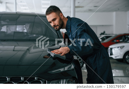 Polishing the vehicle. Car repairman is in the garage with automobile Polishing the vehicle. Car repairman is in the garage with automobile 130179597