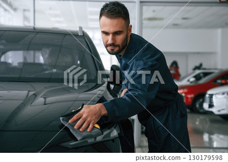Polishing the vehicle. Car repairman is in the garage with automobile 130179598