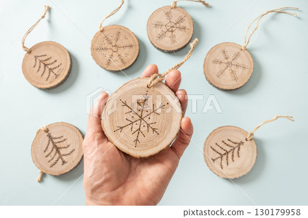 Christmas toy made of decorative wooden slice with ornament. 130179958