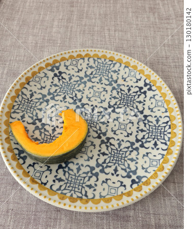 Pieces, slices of pumpkin on porcelain plate with blue pattern. Farm products and healthy eating. Kitchen and home cooking. Pieces, slices of pumpkin on porcelain plate with blue pattern. Farm products and healthy eating. Kitchen and home cooking. 130180142
