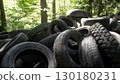 Discarded rubber tires accumulate in a forested area, posing significant risks to local ecology. The pollution disrupts wildlife habitats and contributes to environmental degradation. 130180231