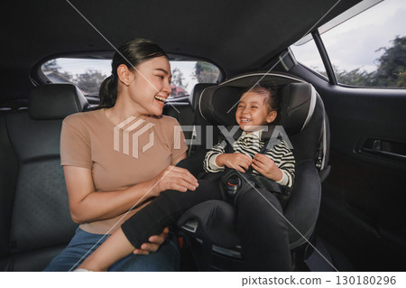 happy mother take care her toddler girl in car seat. play and talking with child happy mother take care her toddler girl in car seat. play and talking with child 130180296