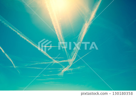 Airplane trails in gradient blue sky 130180358