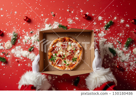 Santa claus holding an opened pizza box against a red background 130180486