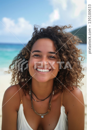 Carefree and joyful young woman with curly hair enjoying tropical beach vacation 130180633