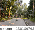Red road sign "Entry prohibited" on the background of yellow autumn leaves. The road is closed with a red round sign. White brick in the red circle of the road sign. 130180798