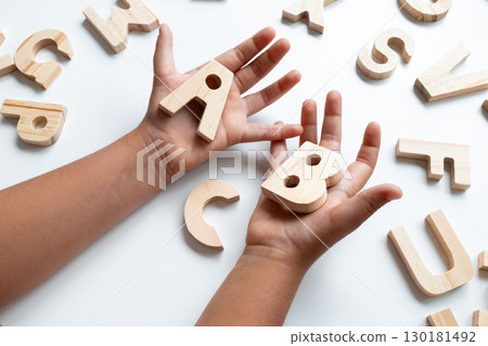 Children wooden alphabet letters held by child hands Children wooden alphabet letters held by child hands 130181492