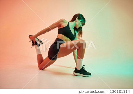 Stretching exercises. Young woman in fitness clothes is in the studio Stretching exercises. Young woman in fitness clothes is in the studio 130181514