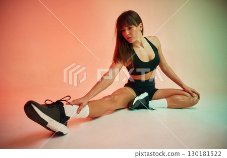 Sitting on the floor. Young woman in fitness clothes is in the studio Sitting on the floor. Young woman in fitness clothes is in the studio 130181522