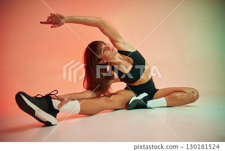 Fitness practice. Young woman in black sportive clothes is in the studio Fitness practice. Young woman in black sportive clothes is in the studio 130181524