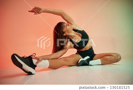 Fitness practice. Young woman in black sportive clothes is in the studio 130181525