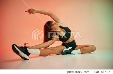Fitness practice. Young woman in black sportive clothes is in the studio Fitness practice. Young woman in black sportive clothes is in the studio 130181526