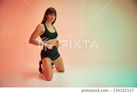 On the knees. Young woman in fitness clothes is in the studio On the knees. Young woman in fitness clothes is in the studio 130181527