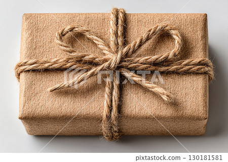 Present for celebration. Minimalist brown Kraft Gift Box with twine bow on white background. 130181581