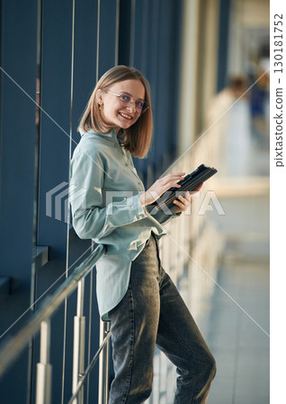 Digital tablet in hands. Young woman in airport hall Digital tablet in hands. Young woman in airport hall 130181752
